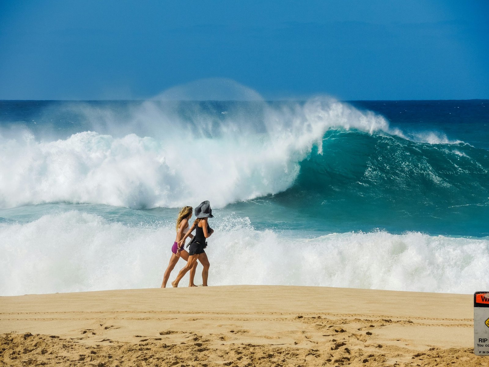 two women walking on shore